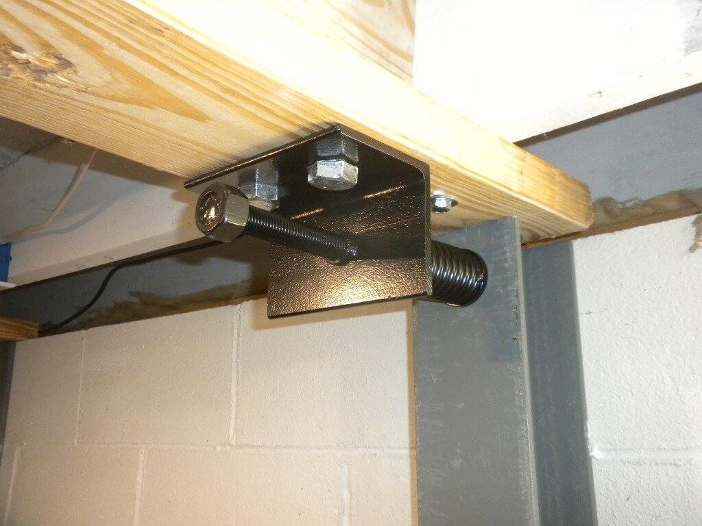 Black Spring Bracket for Steel I Beams Installed On Block Wall | Bowing Wall Repair Services | Area Waterproofing