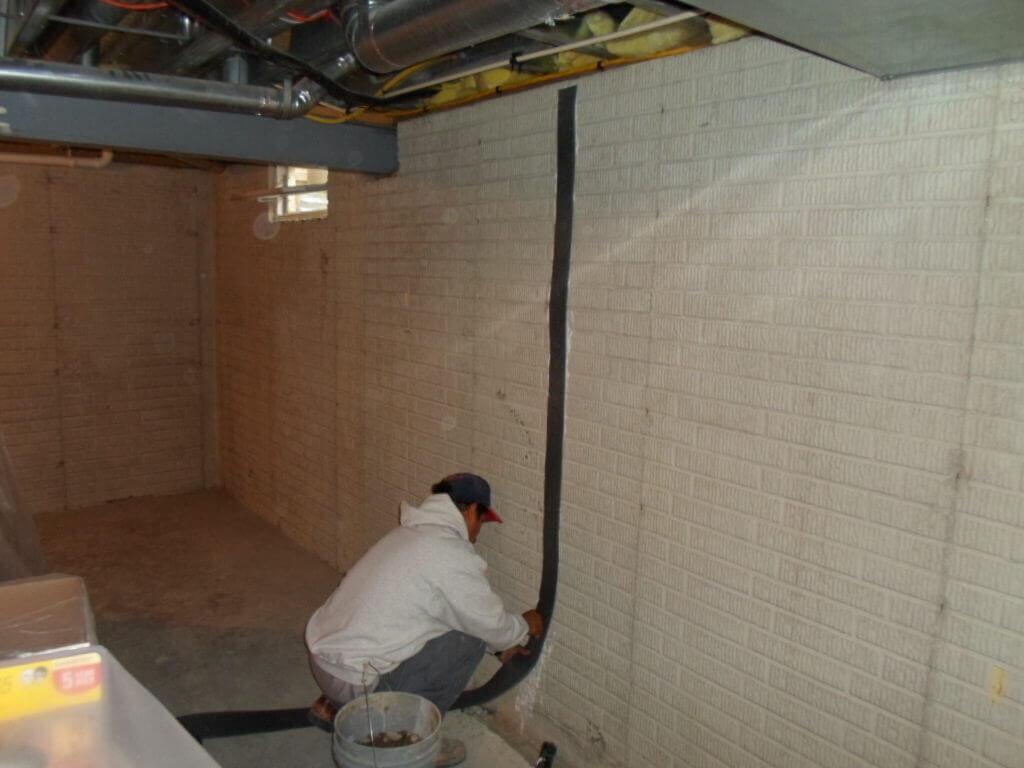 Worker installing a Crack Repair | Foundation Wall | Area Waterproofing
